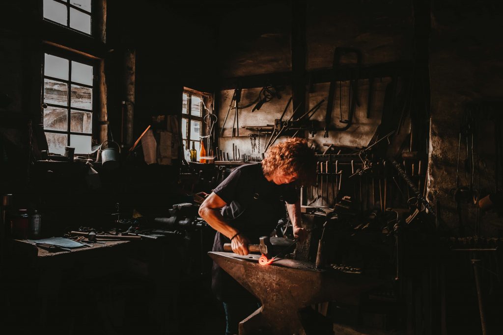 Metalworker using hammer and anvil